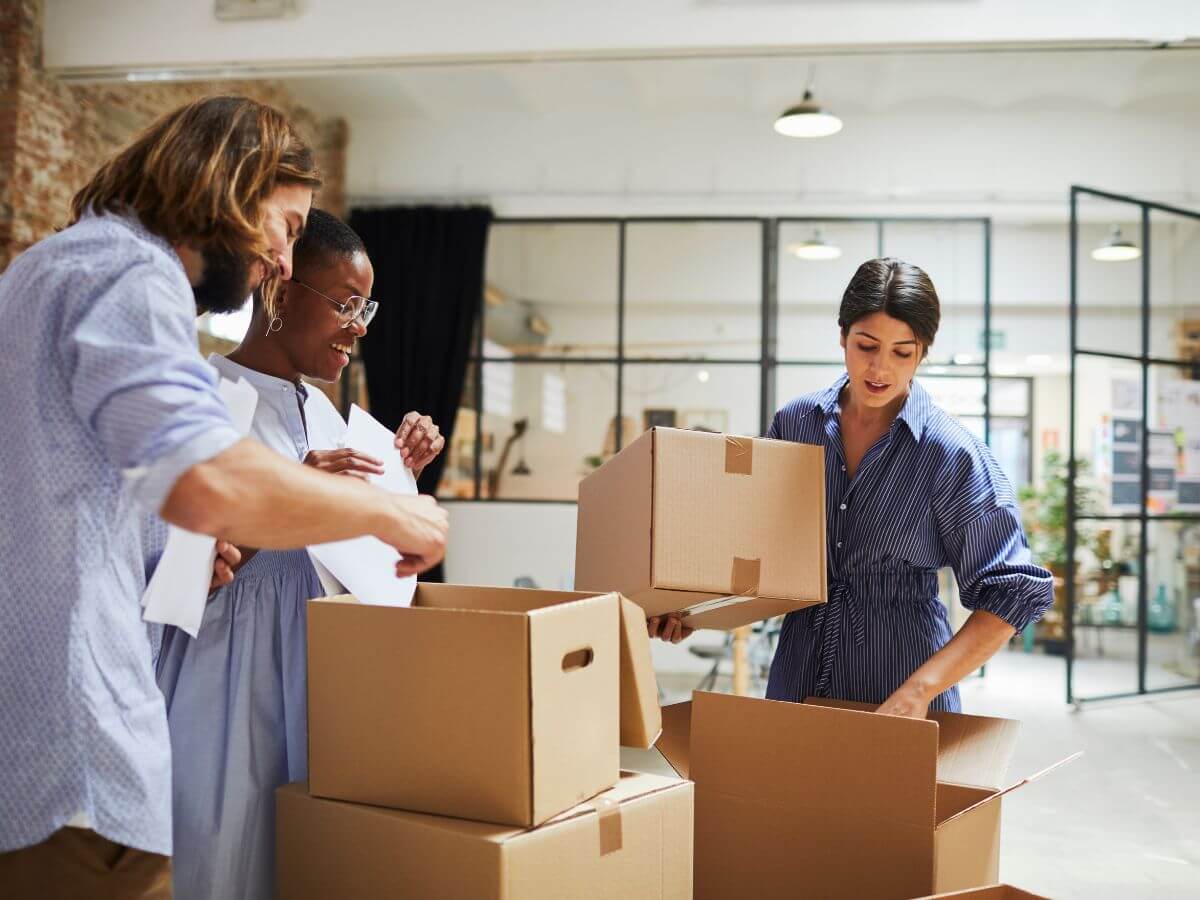 People moving carton boxes and preparing for the office relocation